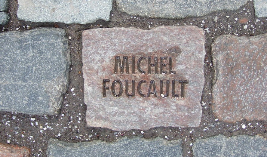 Tom Fecht: »Kaltes Quadrat«, Bonn 2006, Installation am Eingang zur Bundeskunsthalle, Pflasterstein zur Erinnerung an Michel Foucault, CC BY-SA 2.0 DE https://commons.wikimedia.org/wiki/File:Stone_BKH1.JPG 